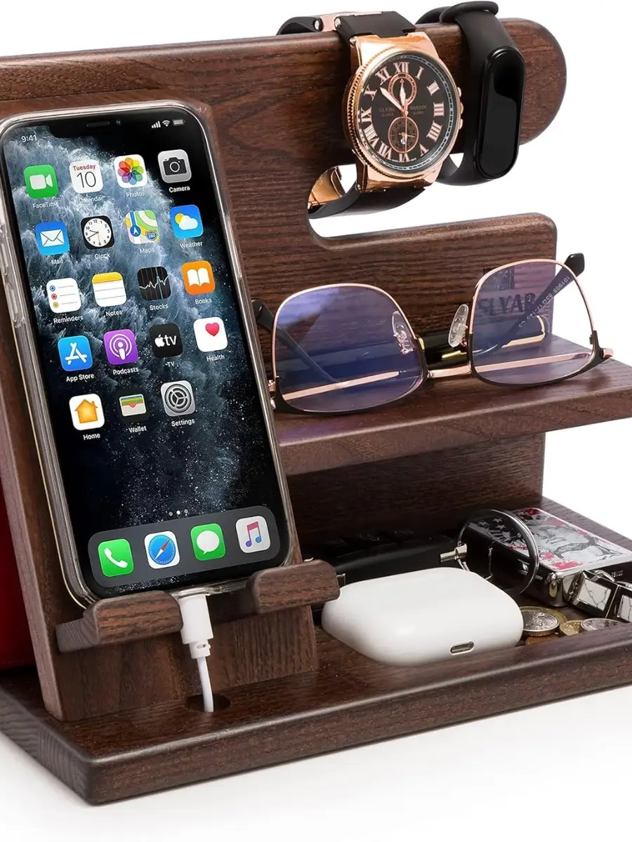 The Ultimate Stylish Wood Docking Station: A Perfect Gift A multi-functional dark wood docking station holding a charging iPhone, a gold wristwatch, a fitness tracker, and prescription glasses on a tiered shelf.