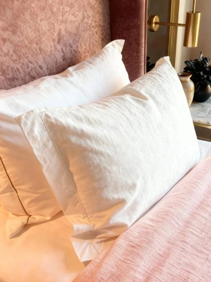 White French linen pillows on a plush pink velvet bed—a practical luxury gift guide.
