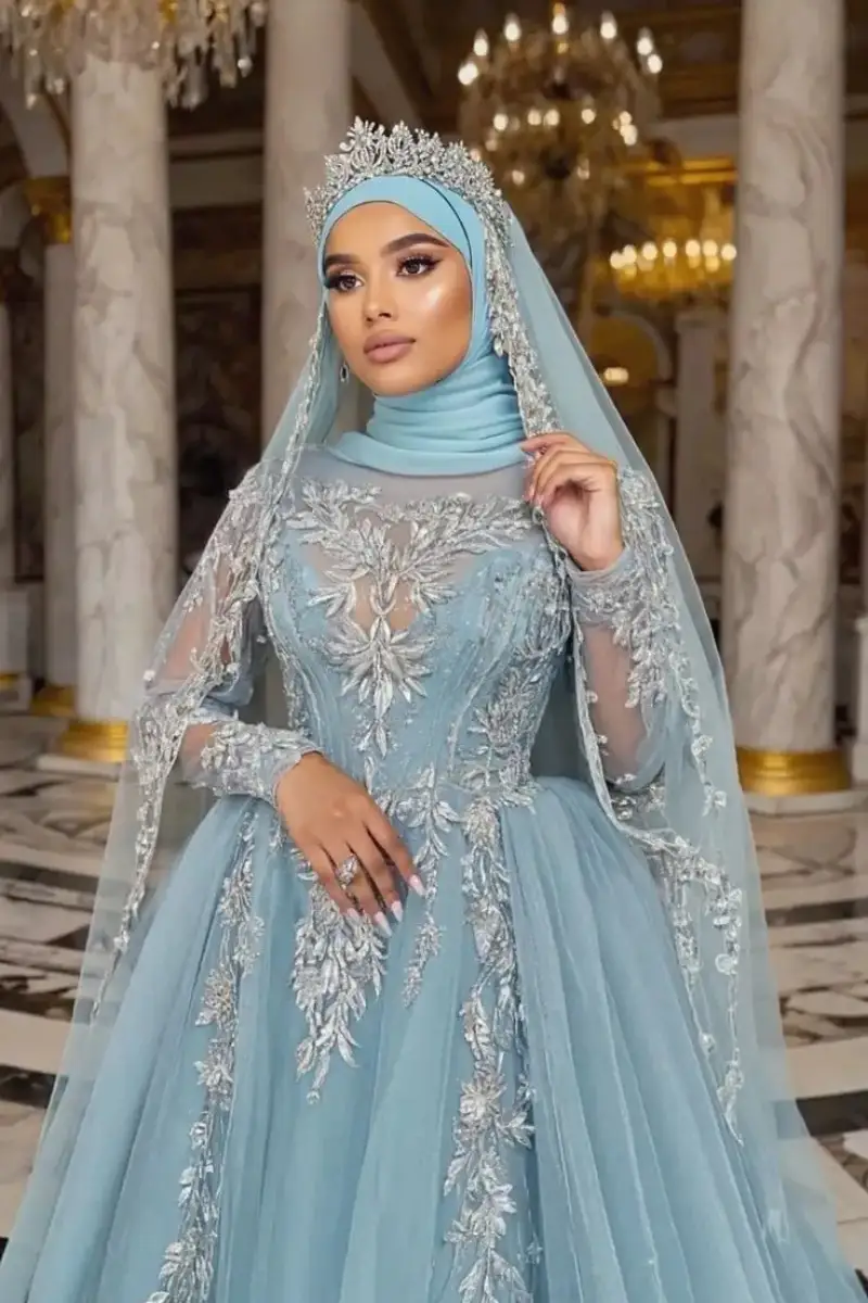 Modest light blue Muslim Arabic wedding dress with intricate silver embroidery, matching hijab, and a crystal crown, illustrating affordable luxury fashion for bridal styling in 2026.