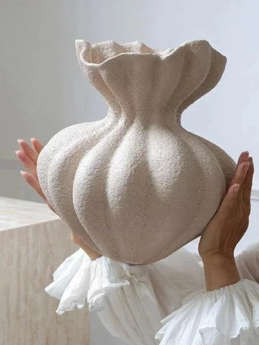 Sculptural white ceramic ruffled vase with a textured, unglazed surface.