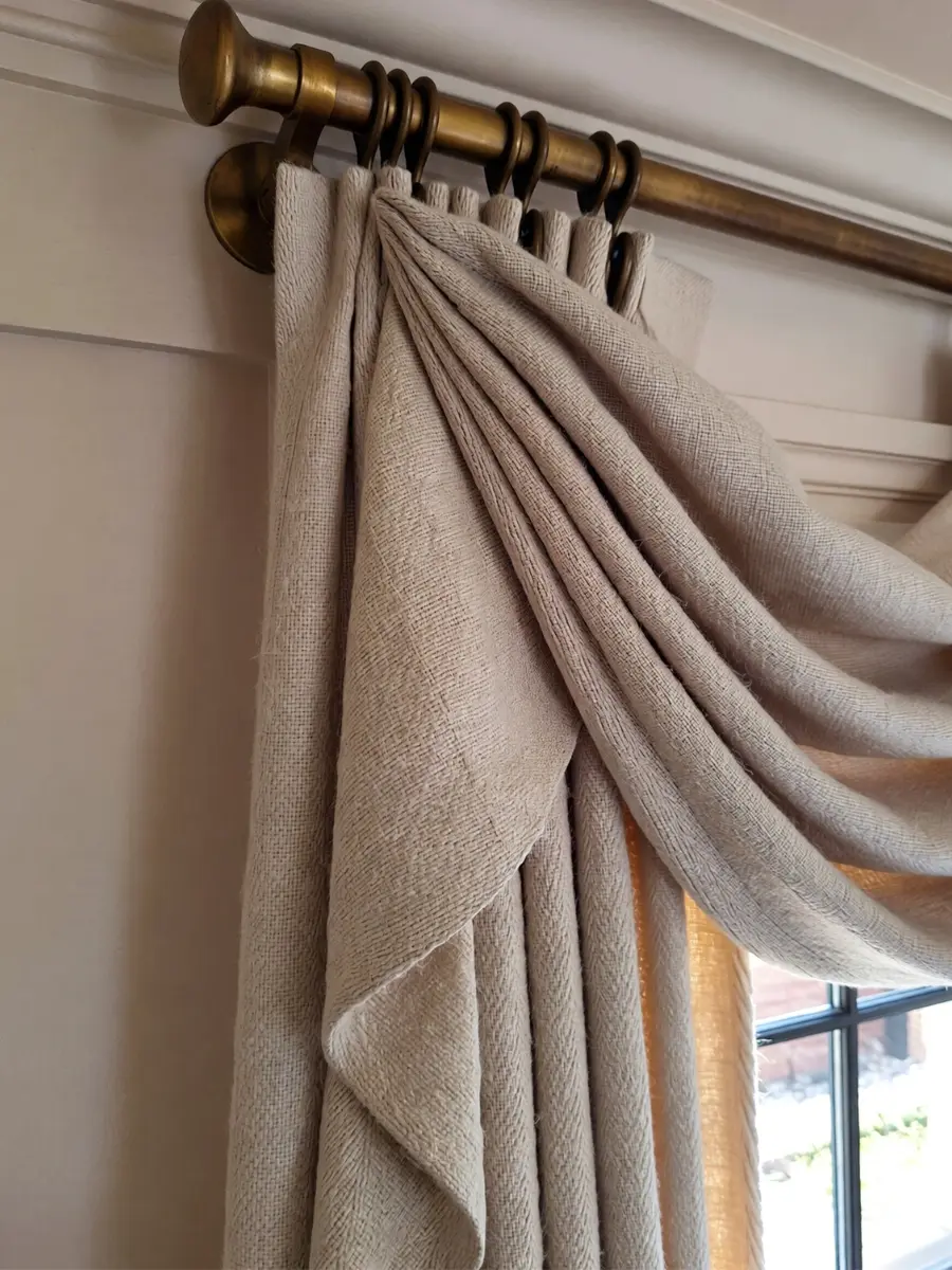 Floor-to-ceiling linen curtains hung high and wide according to affordable luxury interior design rules.