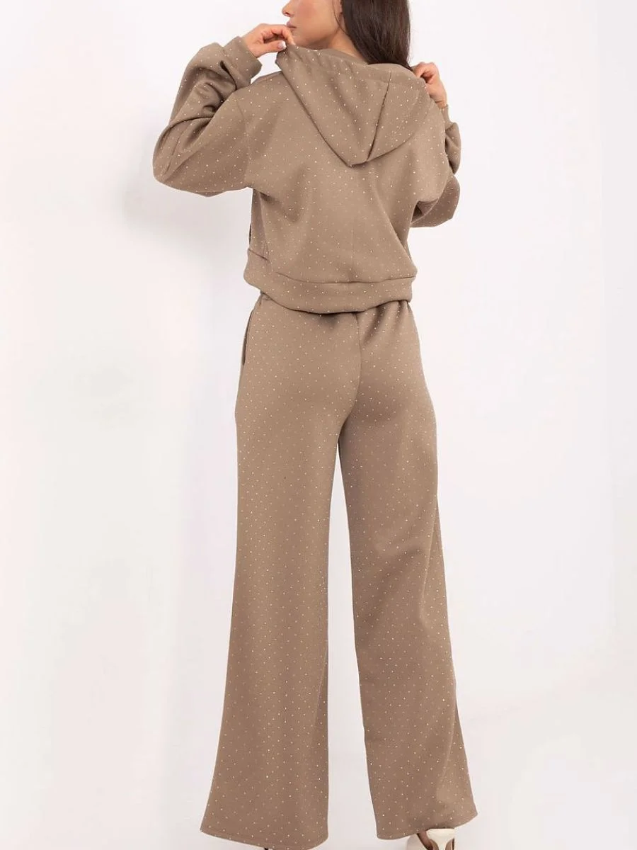 Rear view of a model styling a brown Rue Paris two-piece rhinestone knit lounge set, highlighting the casual hoodie design and the elegant drape of the wide-leg pants.