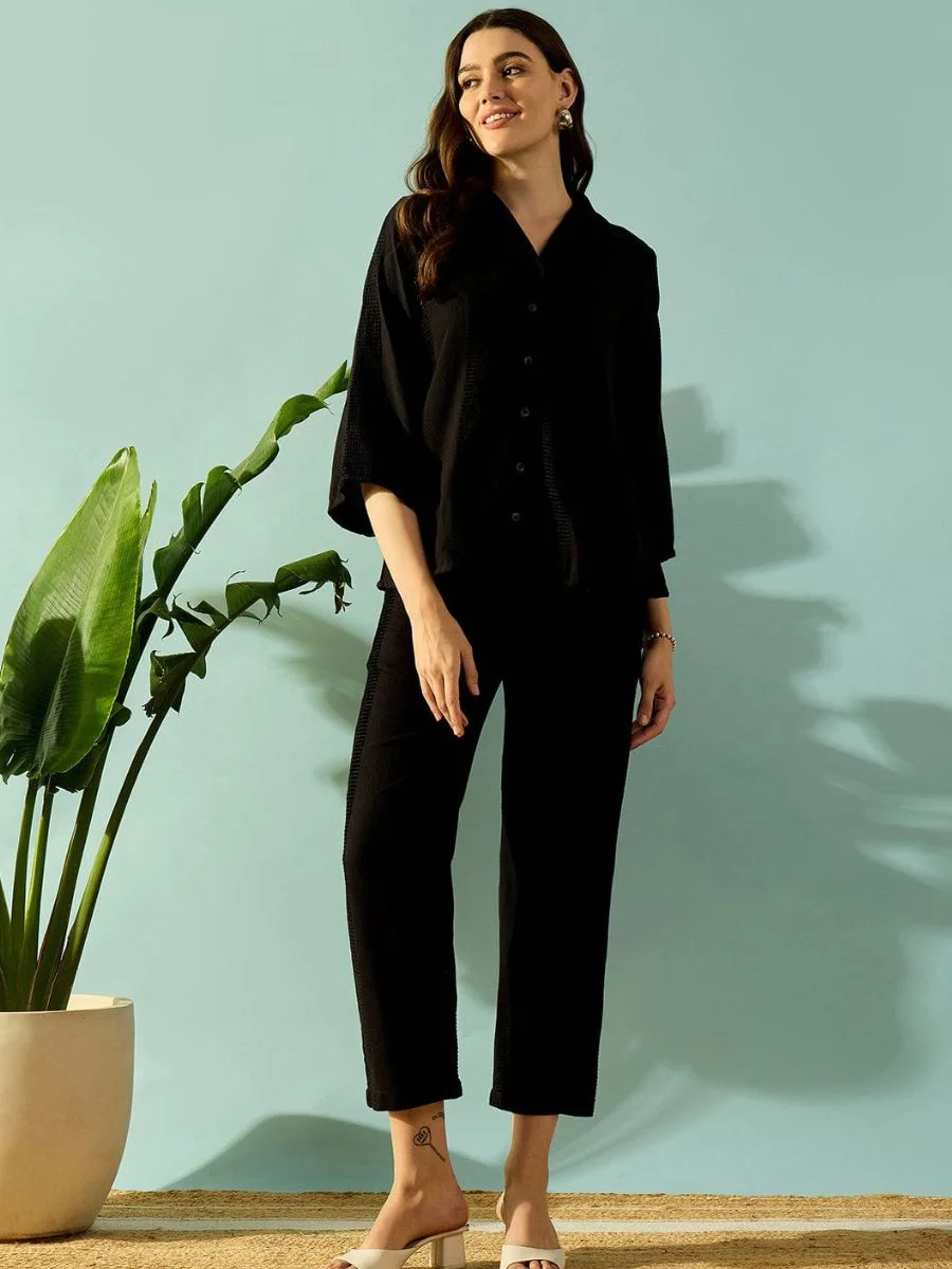 A matching black textured cotton kaftan pantsuit set with a notch collar and straight-leg trousers.
