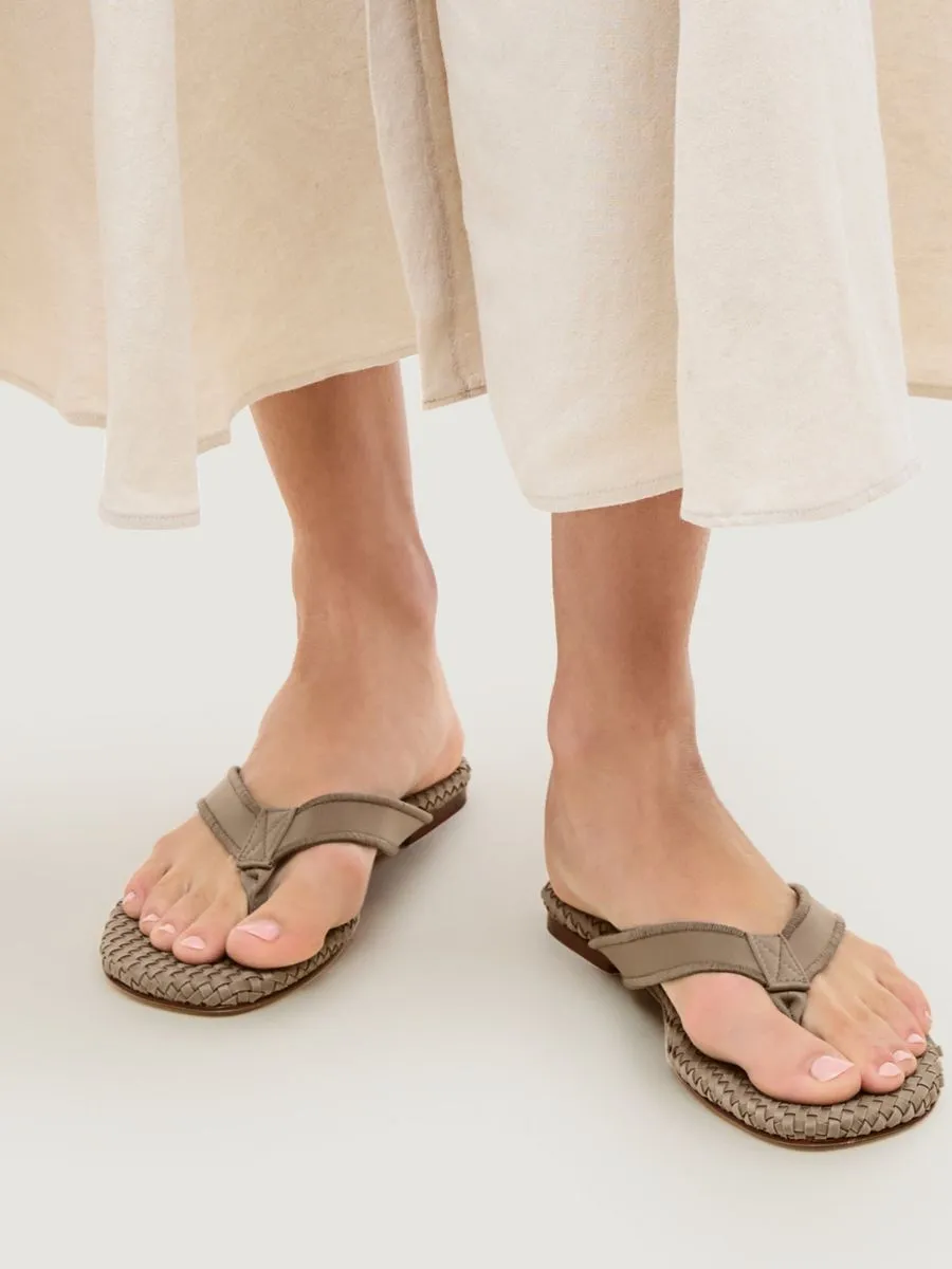 A woman wearing the Cartolina Nantucket Hydra Flip Flop in Cashmere styled with a flowing ivory pleated linen midi skirt.
