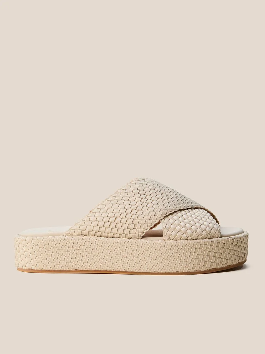 A side-profile view of the Cartolina Nantucket Laguna Platform in Ecru featuring wide cream handwoven crossover straps and a matching wrapped platform base.