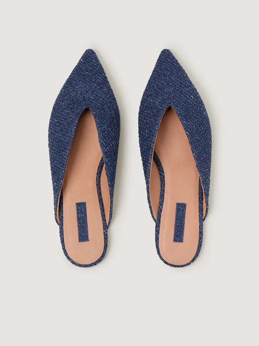 A close-up view of the pointed-toe Cartolina Nantucket Strada Mule in rich indigo denim textile resting on a marble surface.