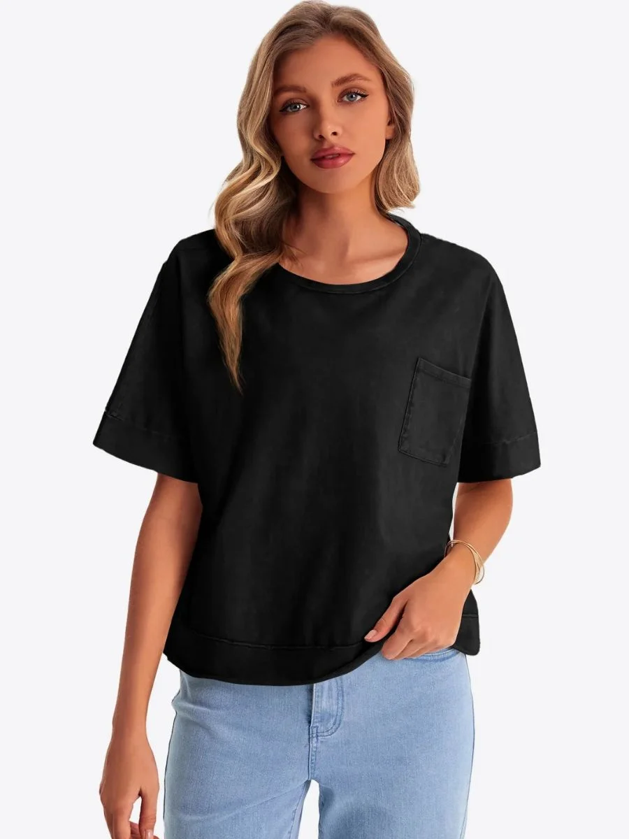  Front view of a woman wearing a black cropped oversized t-shirt with light blue jeans.