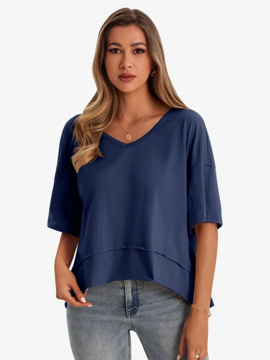 Front view of a woman wearing a dark blue oversized v-neck t-shirt with blue denim jeans.
