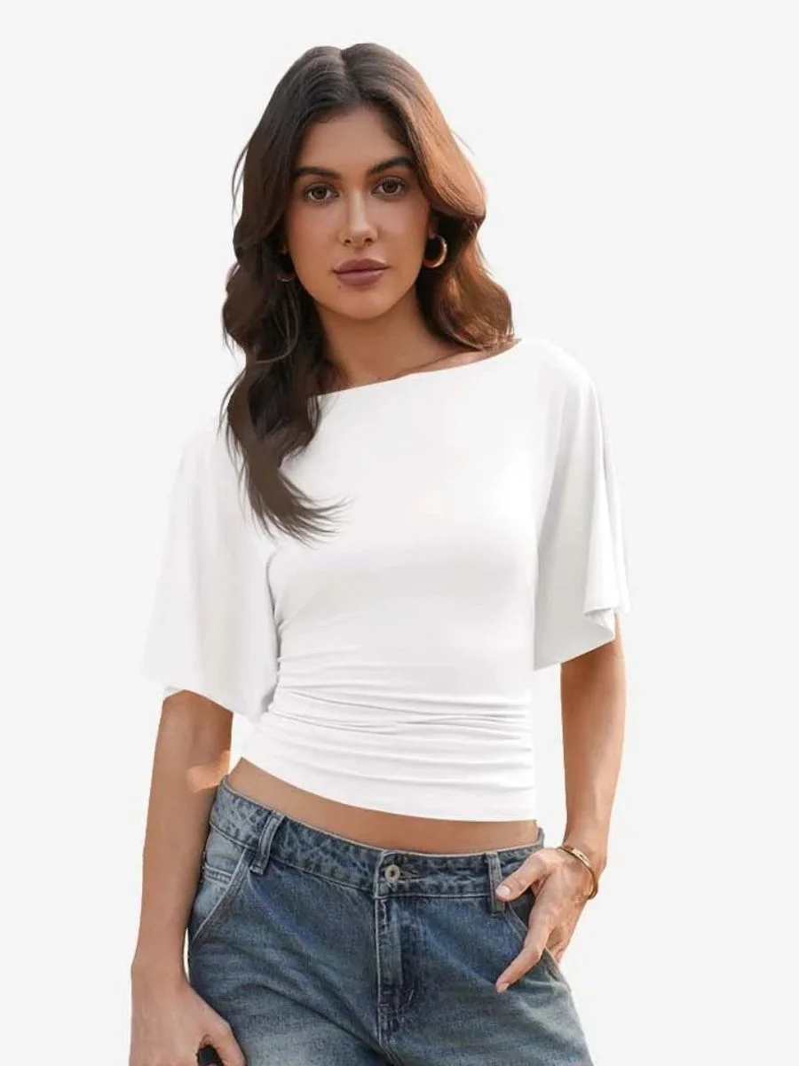 Front view of a woman wearing a white tie-back boat neck t-shirt with wide-leg blue jeans.