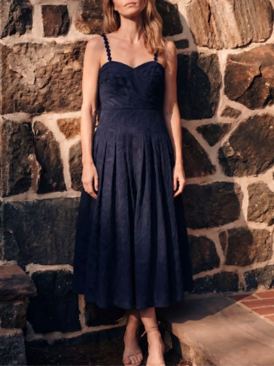 A tailored dark jacquard gown, illustrating how chic pre-fall transitional midi dresses ground sleeveless styles for cooler weather.