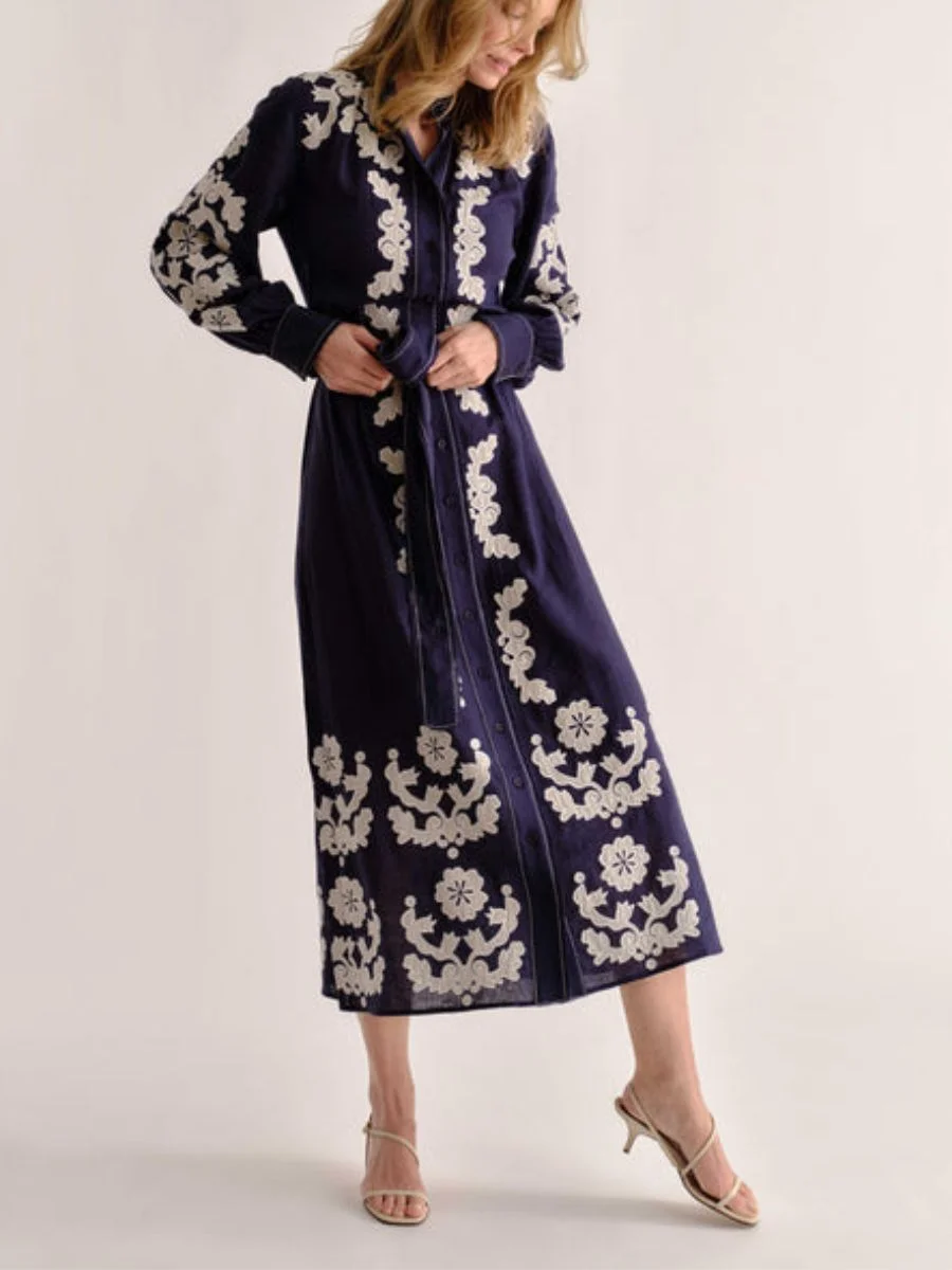 A long-sleeve botanical printed dress, proving how chic pre-fall transitional midi dresses use dark bases for autumn florals.
