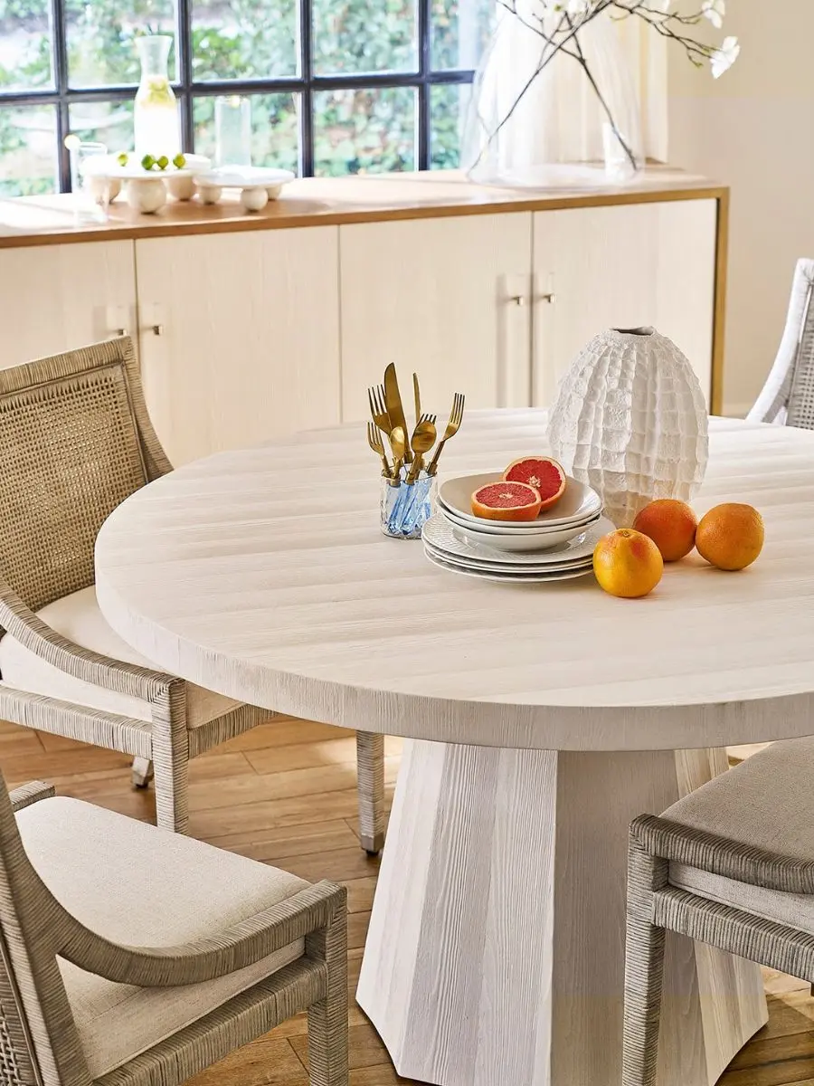Old Money Home Decor: Easy Styling Steps to Make an Average Room Look High-End Textured white ridged ceramic vase styled with grapefruit accents on a round light wood dining table. Elegant coastal traditional dining room table centerpiece ideas.