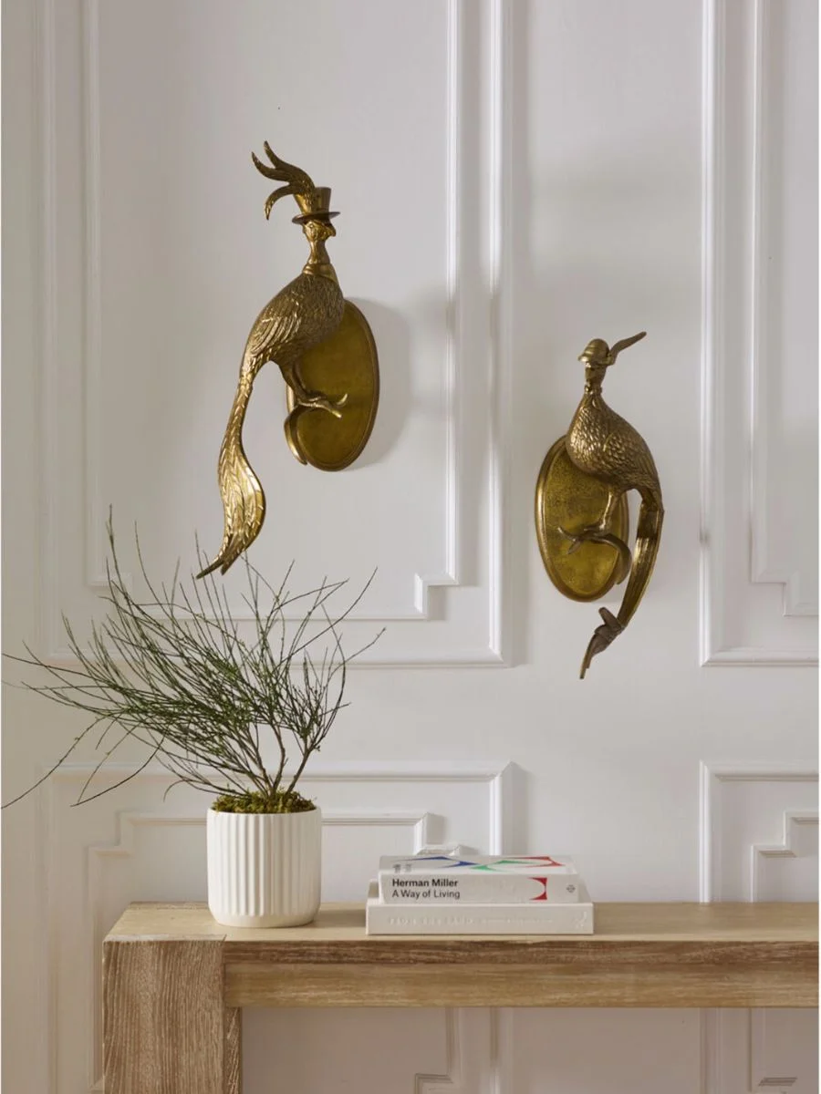 Old Money Home Decor: Easy Styling Steps to Make an Average Room Look High-End A pair of Regina Andrew Distinguished Pheasant Wall Mounts in an antique gold finish hanging on a white paneled wall above a rustic light wood console table.