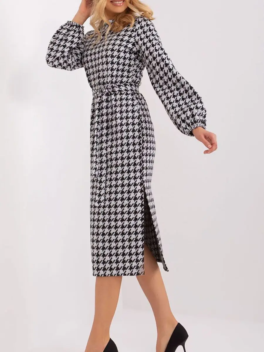 A long-sleeve houndstooth peplite garment, proving how chic pre-fall transitional midi dresses use geometric heritage patterns to drop summer vibrations.