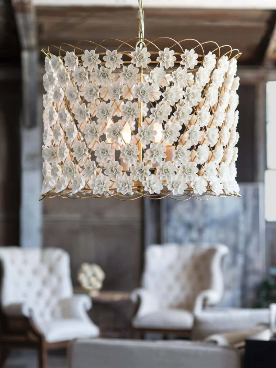 7 Layered Lighting Looks: How to Style Elegant Wall Sconces and Lamps Close up of a Regina Andrew Alice drum chandelier featuring matte white porcelain flowers and gold leaf frame.