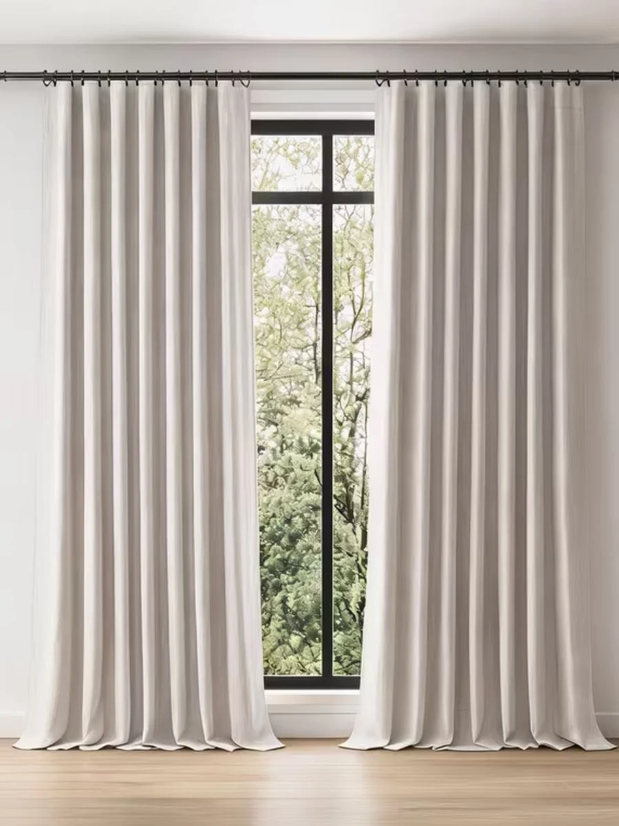 A clean lifestyle photo showcasing floor-length, textured pure flax linen curtains in a neutral farmhouse living room setting.