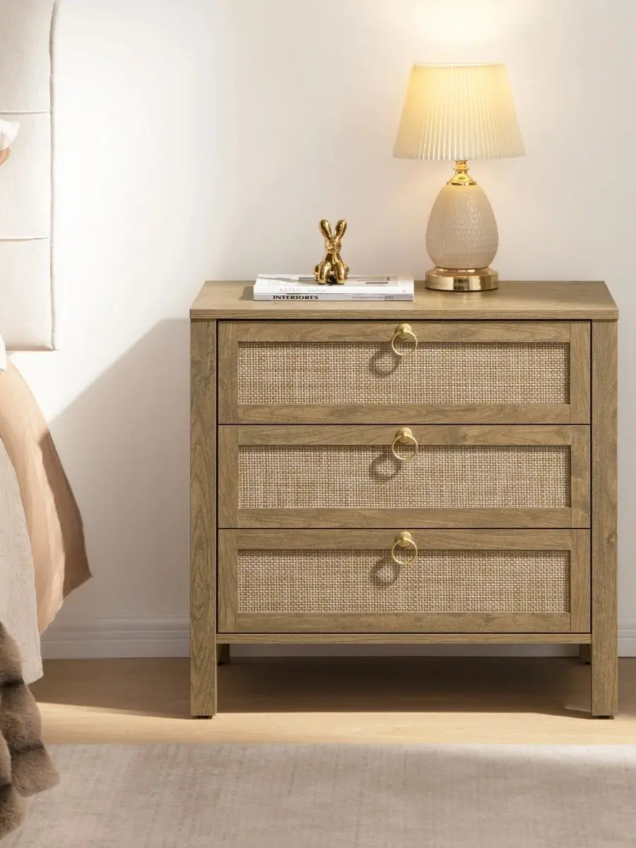 Close-up of a three-drawer nightstand highlighting sleek gold ring pull handles mounted cleanly over intricate woven rattan cane drawer fronts.