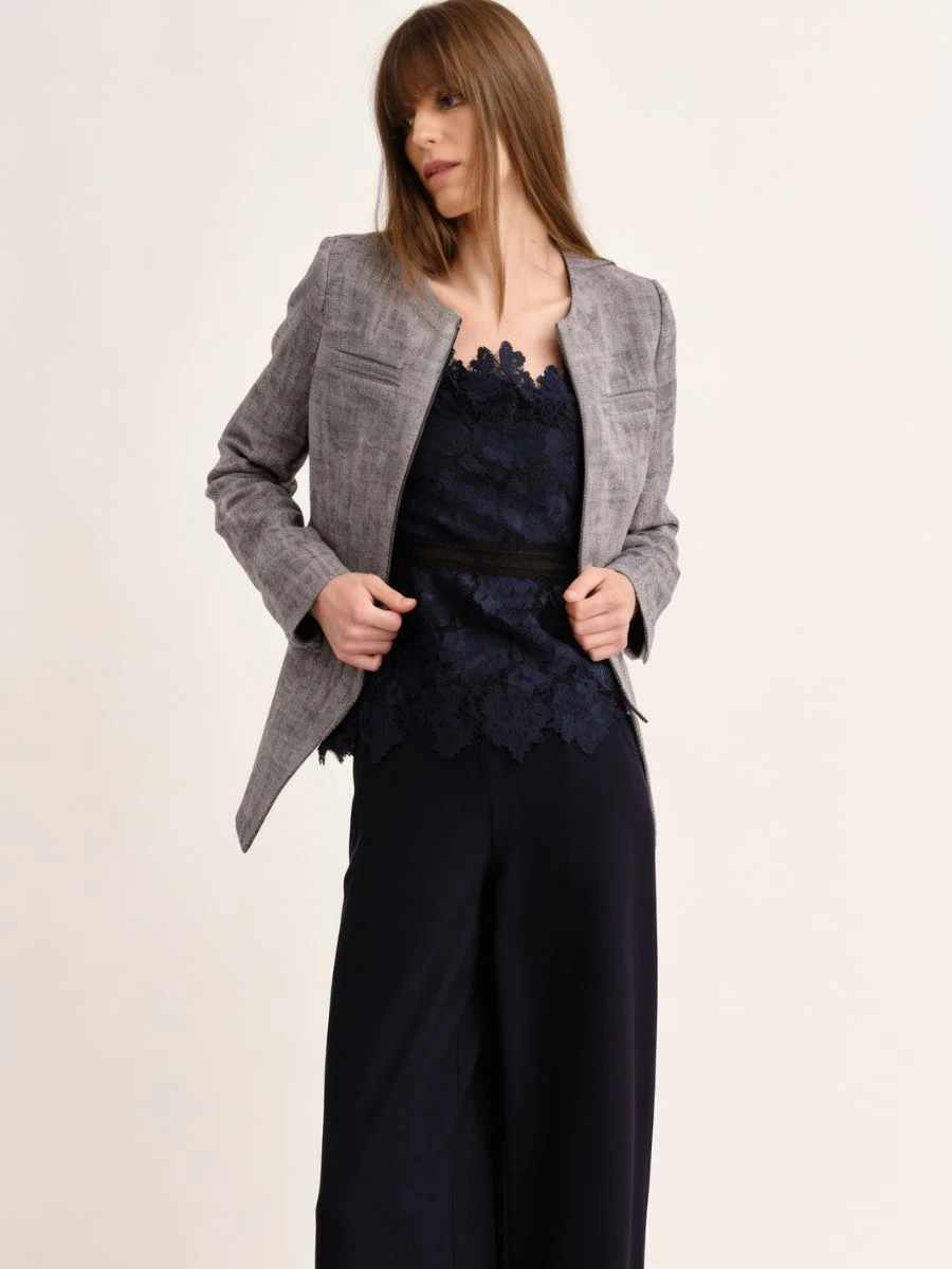 Model wearing a structured, navy blue Cartolina cotton twill jacket with a clean cutaway front over matching trousers.