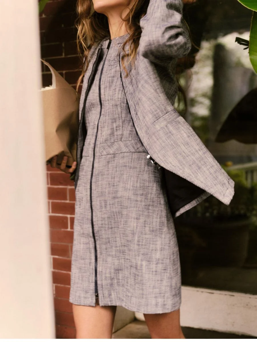 Close-up of a woman wearing the zippered navy Cartolina jacket styled smoothly as a matching monochrome outfit.