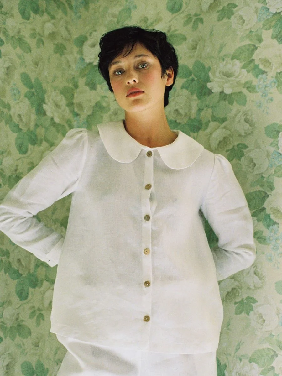 Close up view of the white Má + Lin linen blouse highlighting the double-sided Peter Pan collar and wooden buttons.
