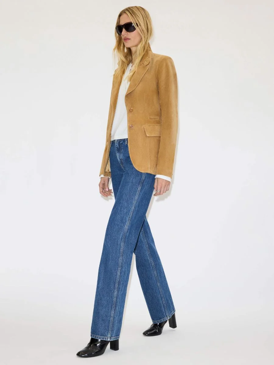 Street style view of a woman wearing the fitted RE/DONE tobacco suede blazer paired with relaxed blue denim.