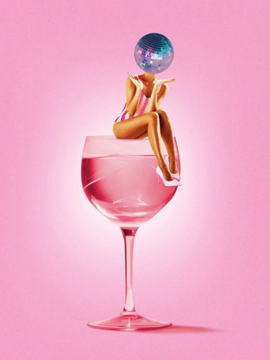  Pop art poster print displaying a retro woman with a disco ball head sitting on the rim of a pink wine glass full of liquid against a matching pink backdrop.