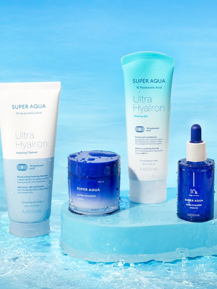 Hydrating skincare set including a tube of foaming cleanser, a jar of cream, a tube of peeling gel, and a blue ampoule bottle on a matching blue backdrop with water droplets.