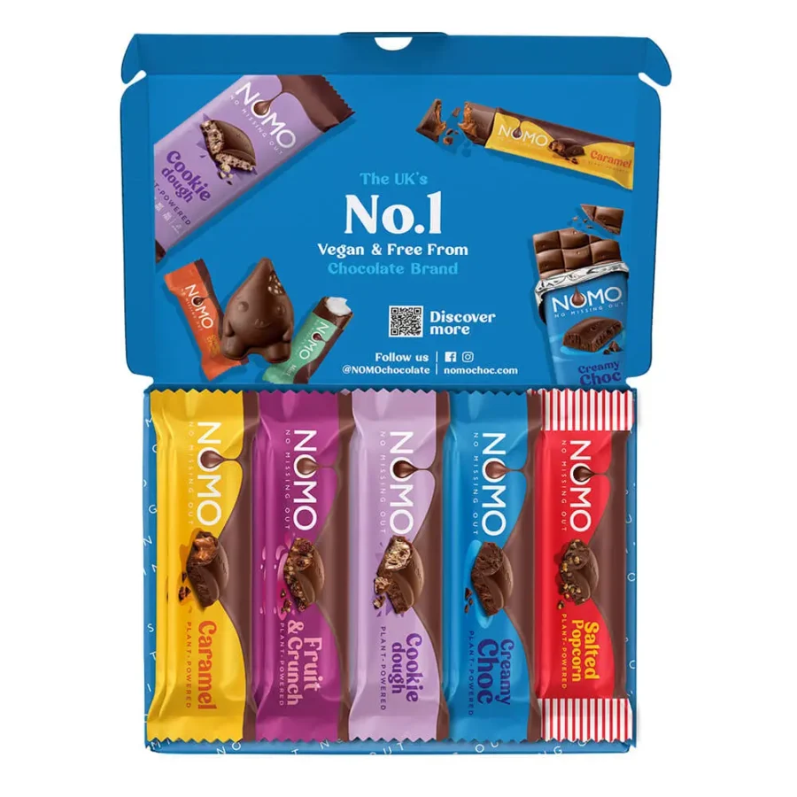 An open bright blue NOMO chocolate gift box displaying a selection of five vegan and free-from chocolate bars including Caramel, Fruit and Crunch, Cookie Dough, Creamy Choc, and Salted Popcorn flavors against a white background.