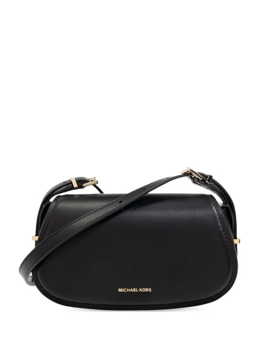 A front view of the black leather Lydia small flat crossbody bag from Michael Kors featuring a smooth curved crescent silhouette, a plain front flap closure with small gold metal brand lettering at the bottom, and a thin adjustable leather shoulder strap against a plain white background.