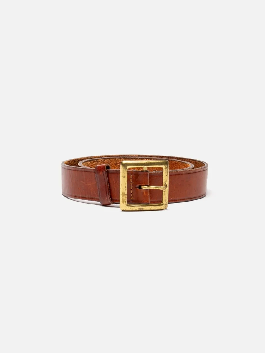 A front view of a coiled brown grain leather belt from RE/DONE featuring an 80s vintage style, a medium width strap, a single leather keeper loop, and a square gold metal buckle with a brushed finish on a plain white background.