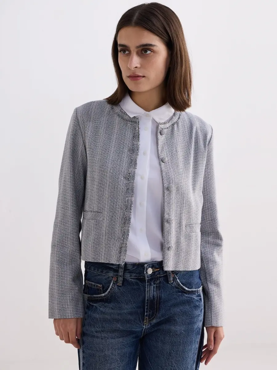 A model wearing a grey Reistor cotton tweed lady jacket featured in the classy capsule wardrobe checklist for styling elegant outfits for women.