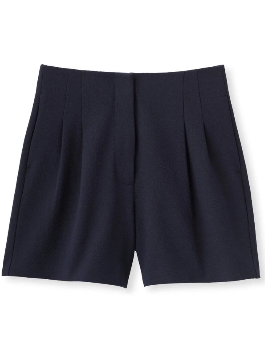 A flat lay image of dark navy tailored trouser shorts from Cartolina featuring a structured waistband, double pleated front, hidden hook-and-bar closure, and functional side pockets.
